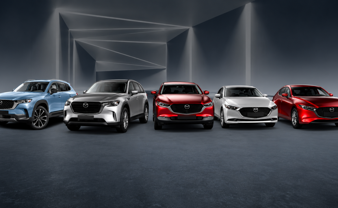 Varios vehículos Mazda de distintos modelos y colores alineados en un espacio de exhibición.